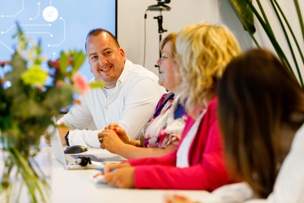 Mensen praten aan een tafel met bloemen